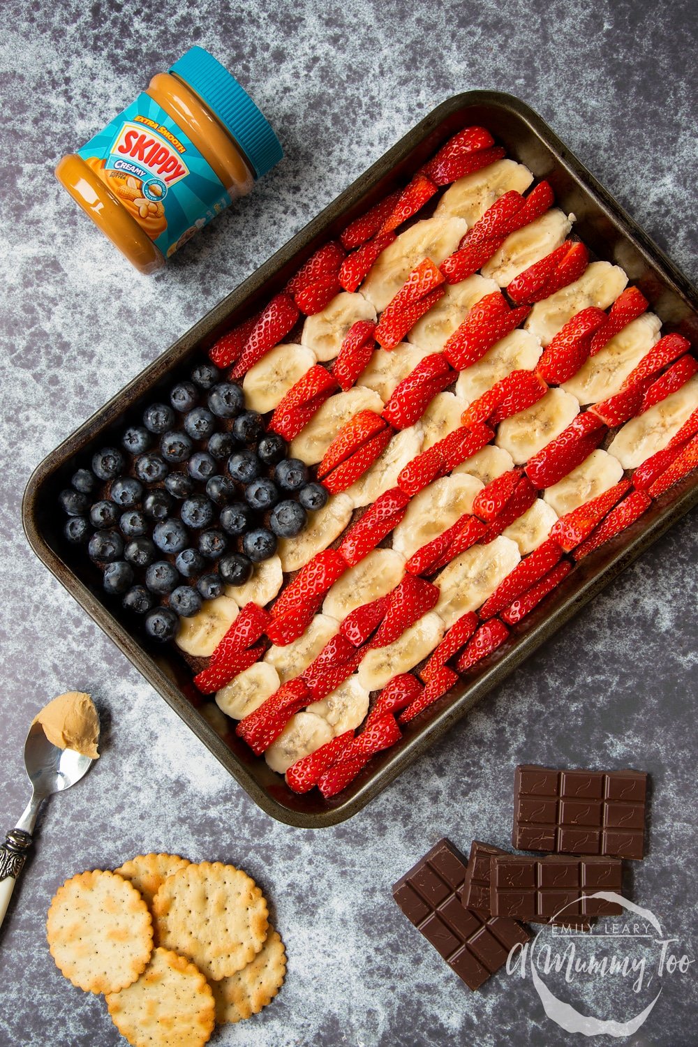 The completed peanut butter brownies tin in the shape of the American flag to celebrate the 4th of July with a tub of Skippy's creamy peanut butter on the side. 