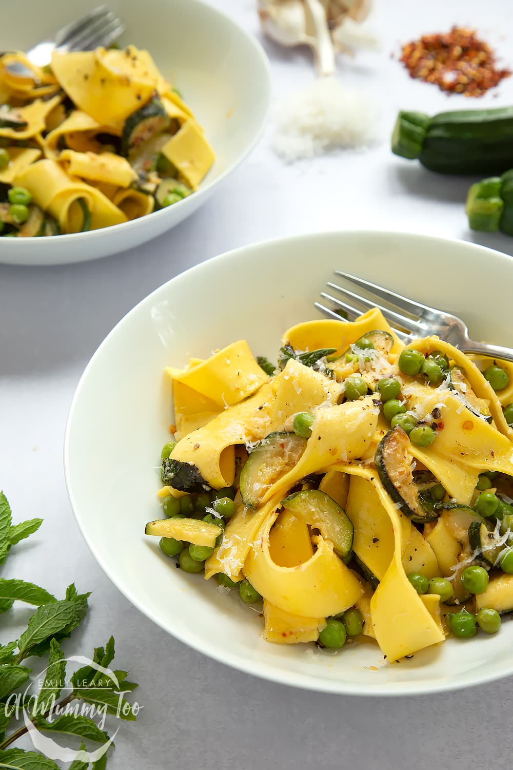 Jamie Oliver's courgette and pea pasta served into two bowls.