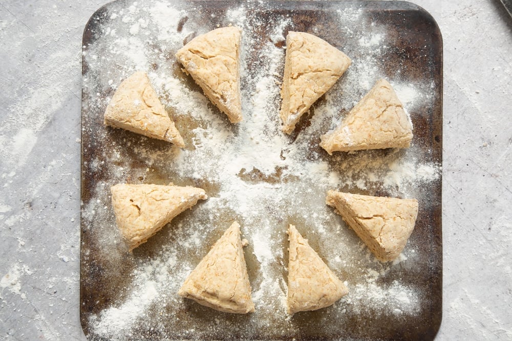 Triangles of scone dough on a floured baking tray