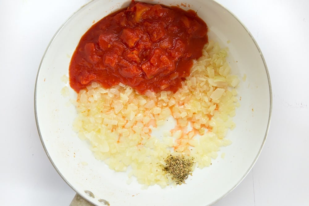 Overhead shot of tomato sauce, onion and garlic in a pan 