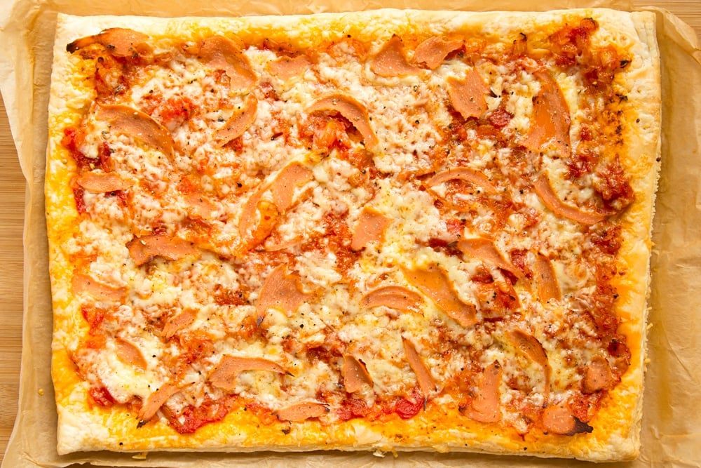 Overhead shot of cooked puff pastry pizza in a baking tray 