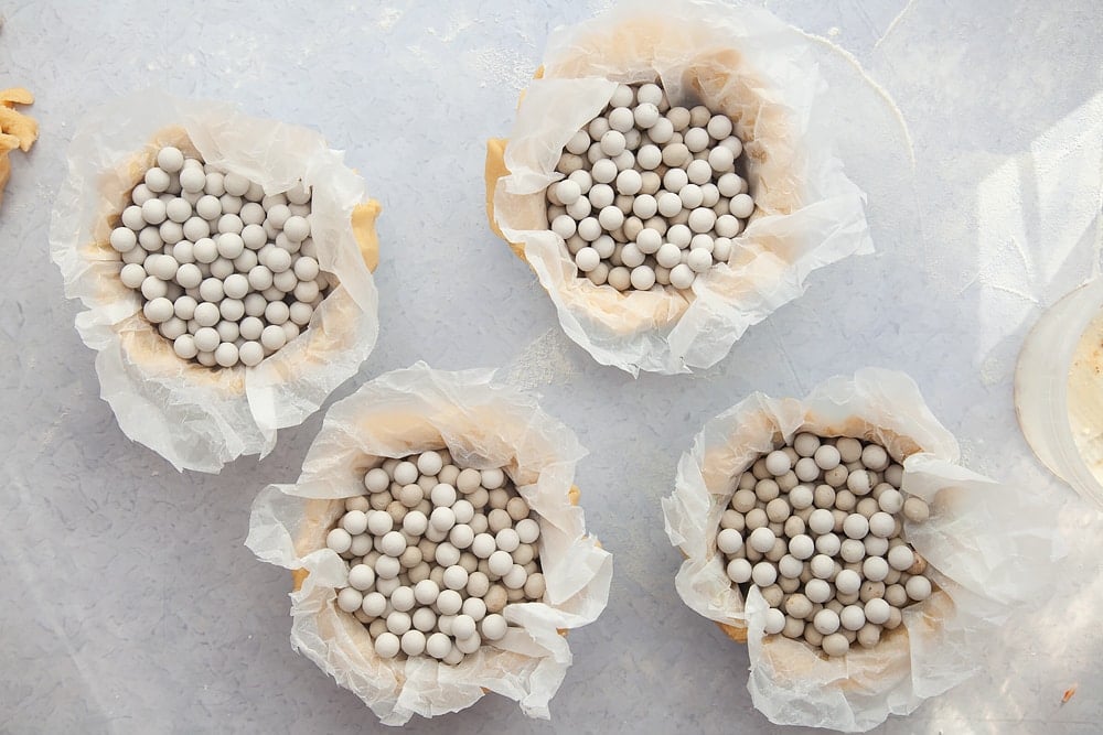 Pastry cases lined with greaseproof paper and baking balls