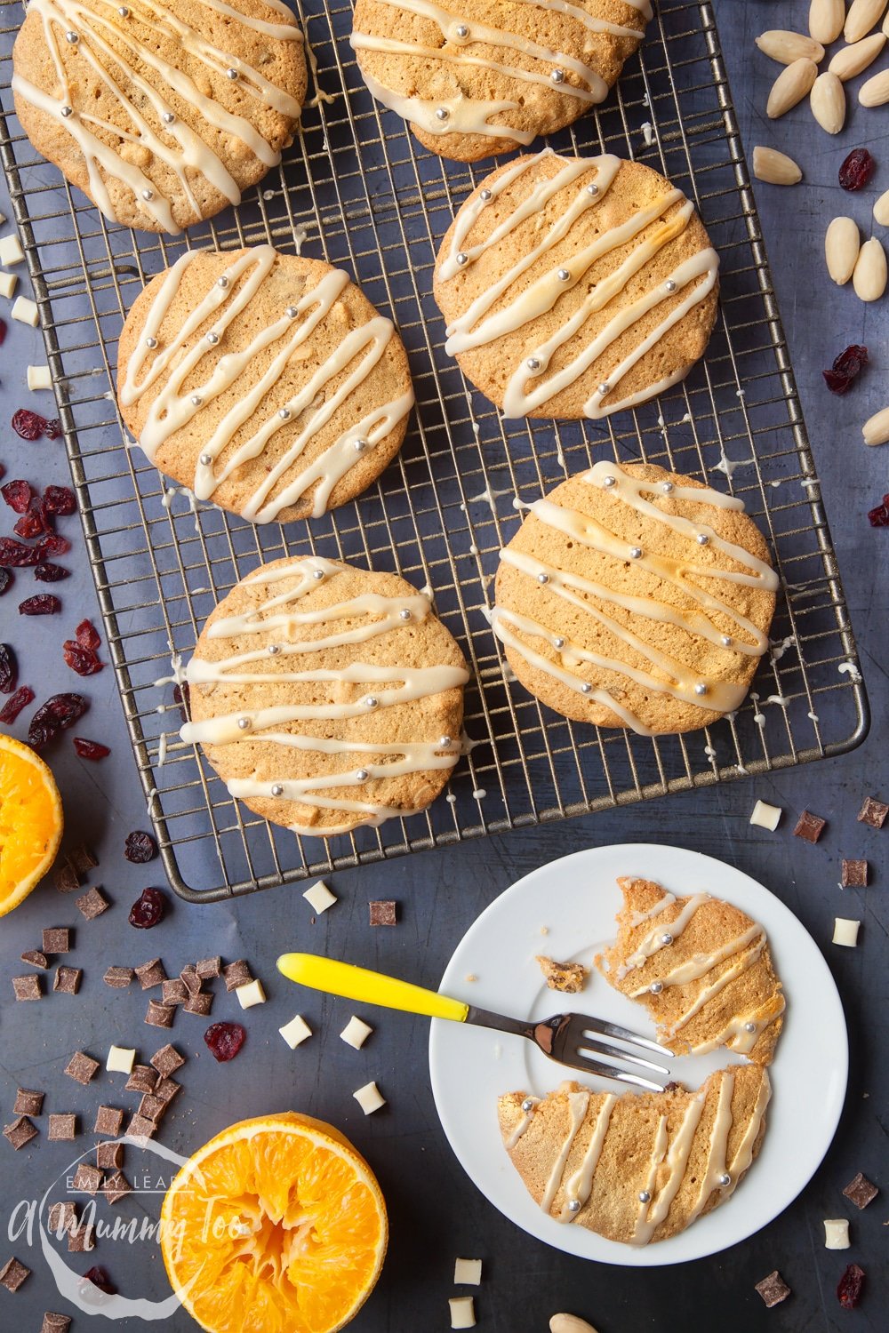 Overhead shot of Cranberry orange white chocolate cookies on a baking rack with a mummy too logo in the lower-left corner