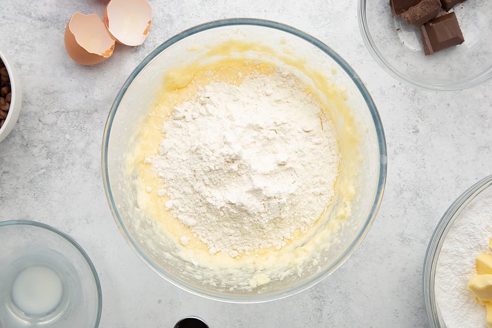 Adding flour to the mixture for the chocolate chip mini-loaf cake with chocolate frosting