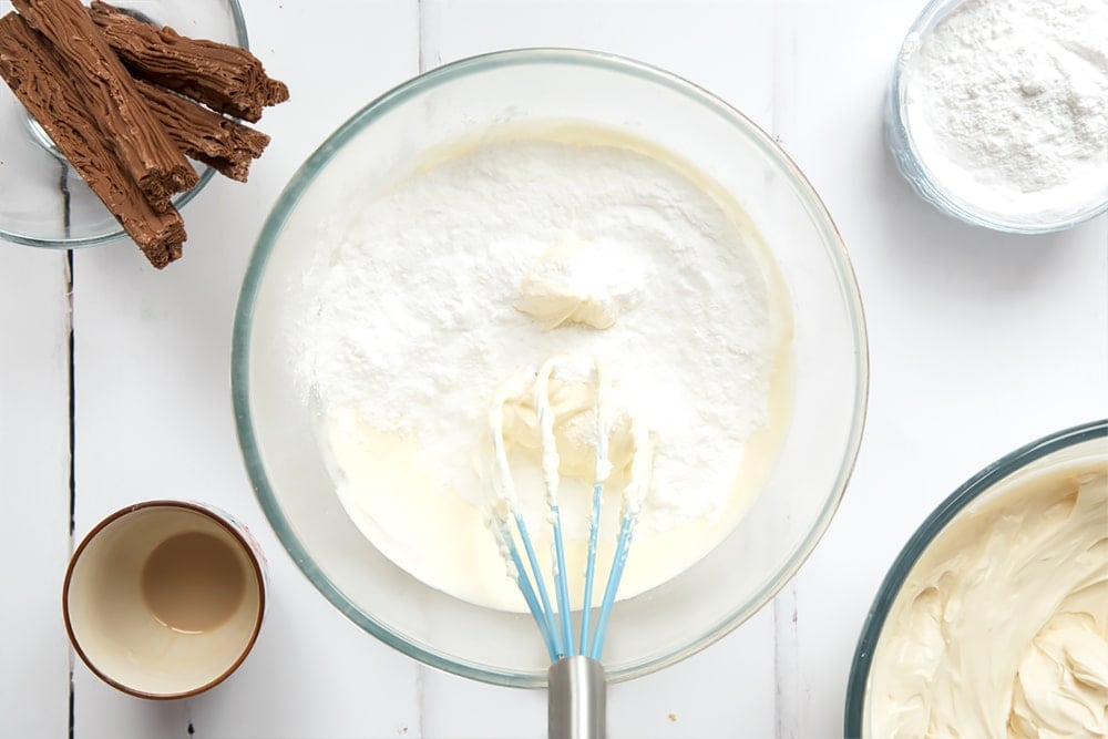 Cream and icing sugar in a mixing bowl.