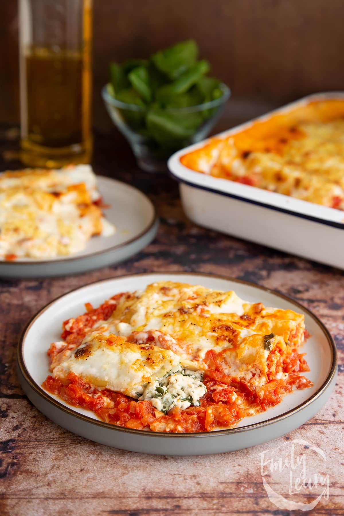 Side on shot of the finished spinach and ricotta cannelloni served on a plate.