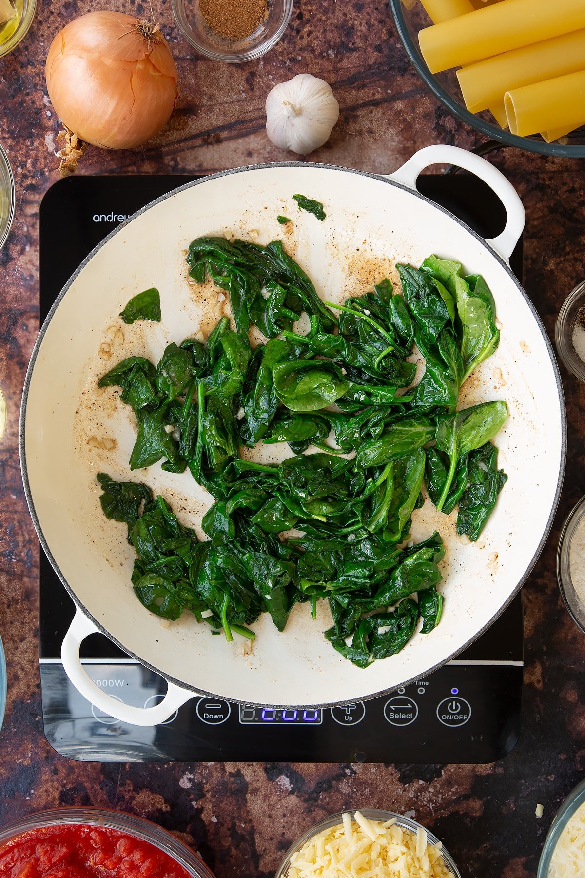 Overhead shot after the spinach has been cooked on the induction hob for a few minutes.