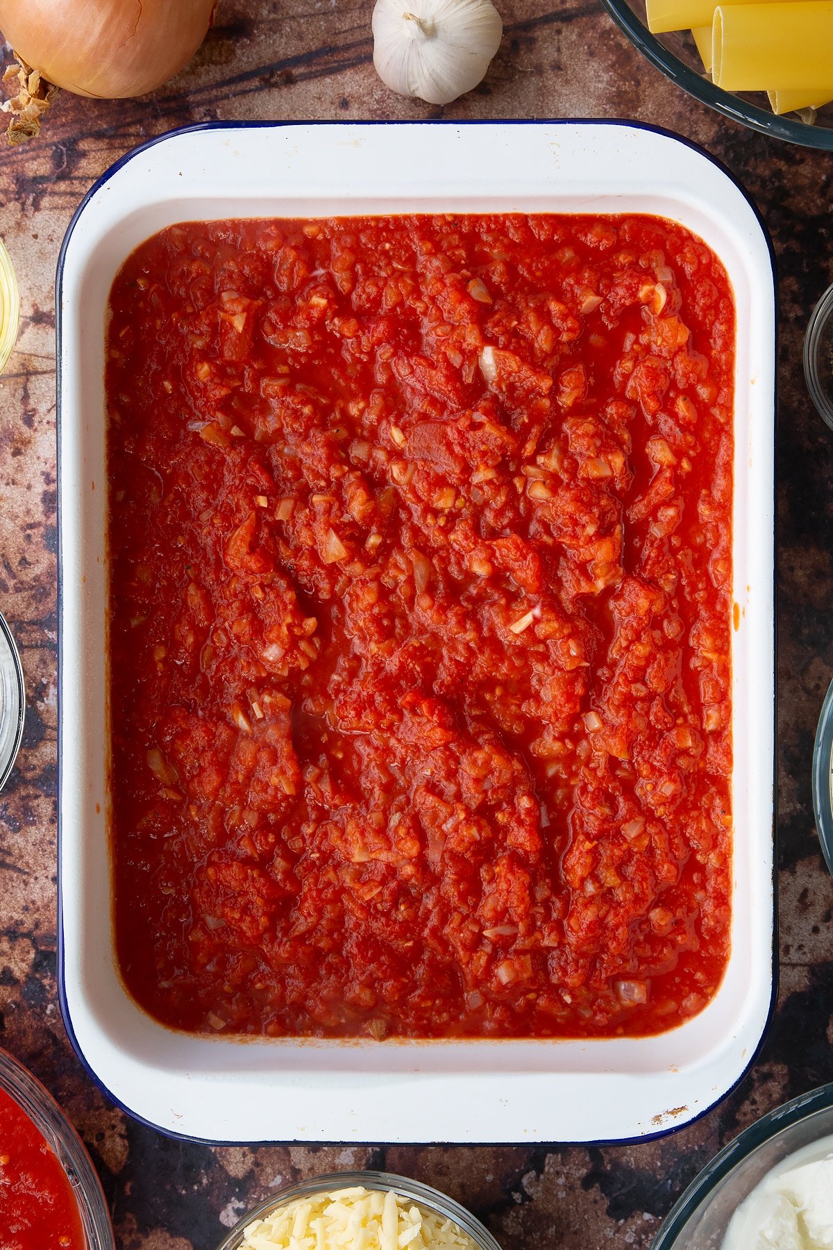 Overhead shot of some of the ingredients for the spinach and ricotta cannelloni together in a baking dish.