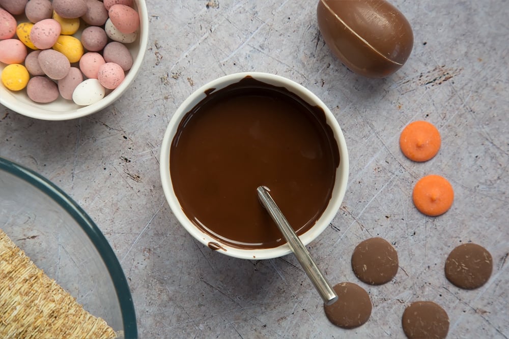 Melted dark chocolate, shown alongside mini Easter eggs