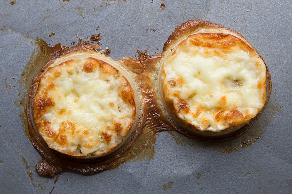 Overhead shot of two crumpets after the egg rings have been removed. 