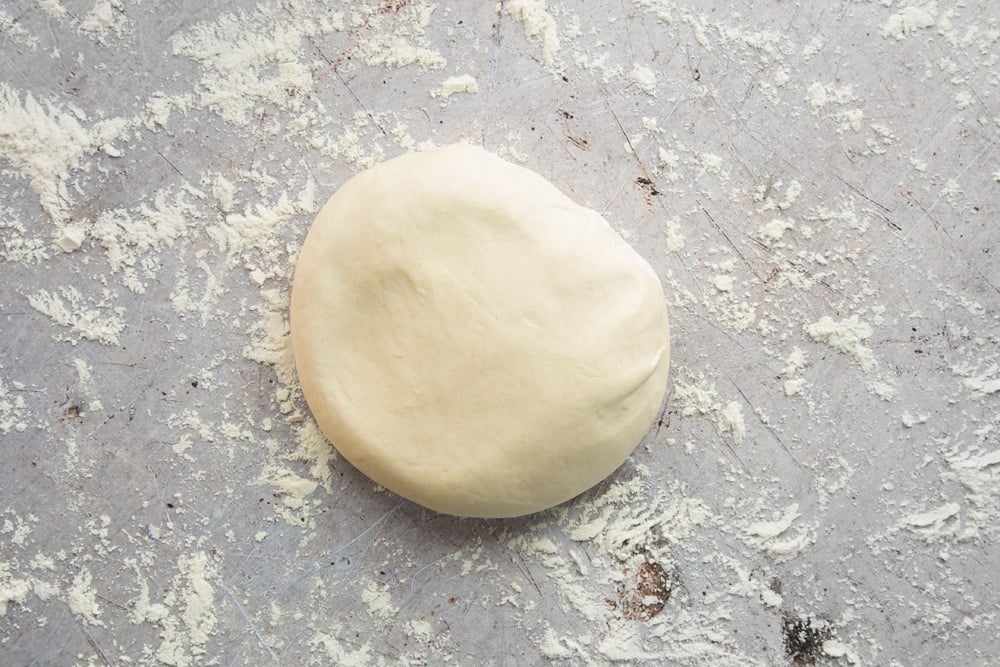 a smooth dough ball on a floured surface.