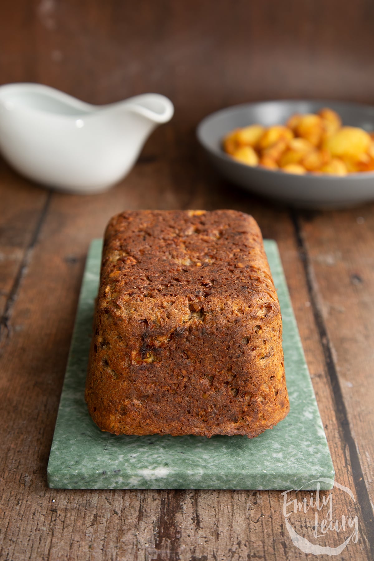 Side on shot of the special k loaf having been removed from the loaf tin and placed onto a blue marble chopping board.