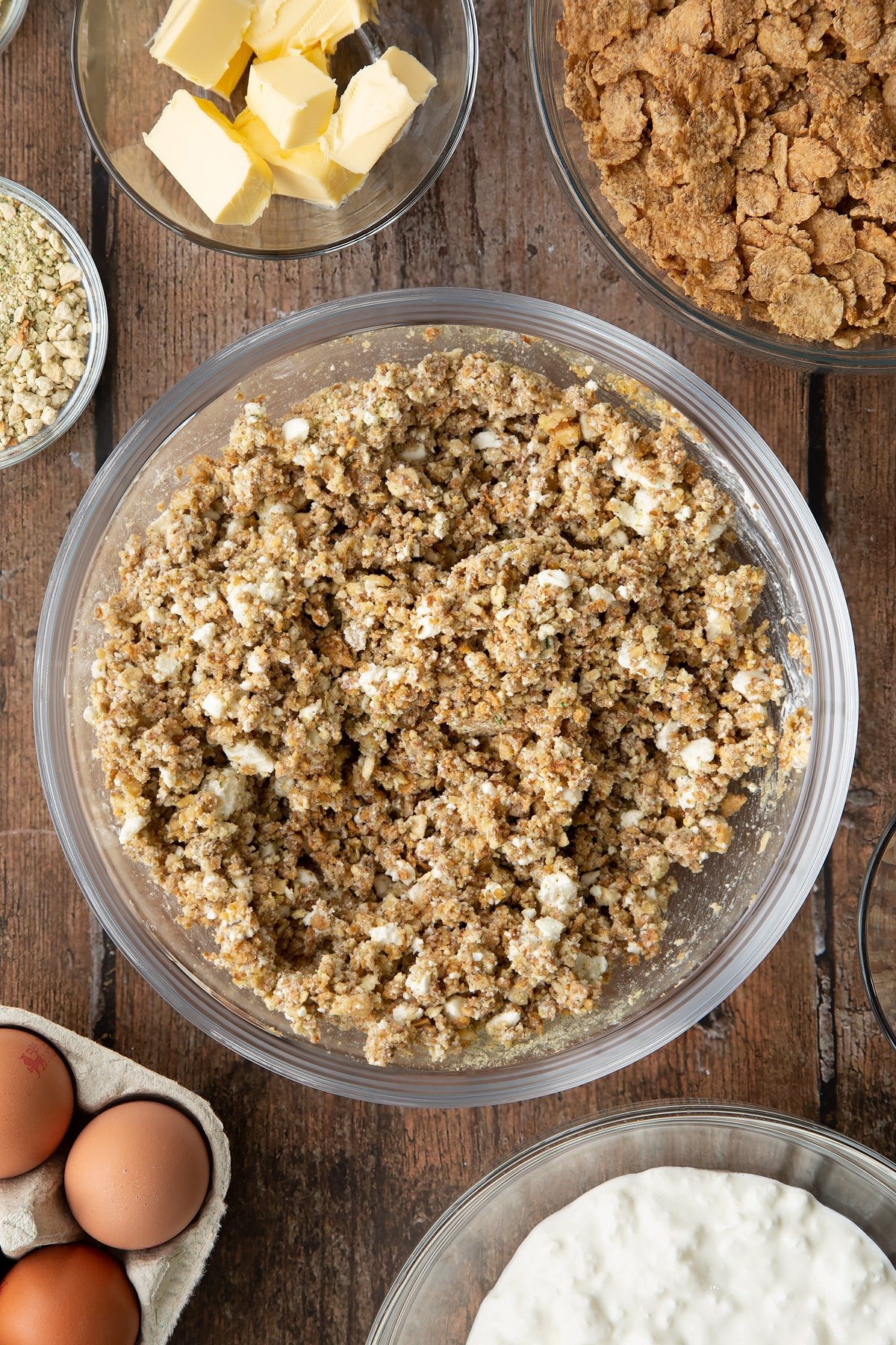 Overhead shot of some of the ingredients required to make the special k loaf mixed together in a clear bowl.