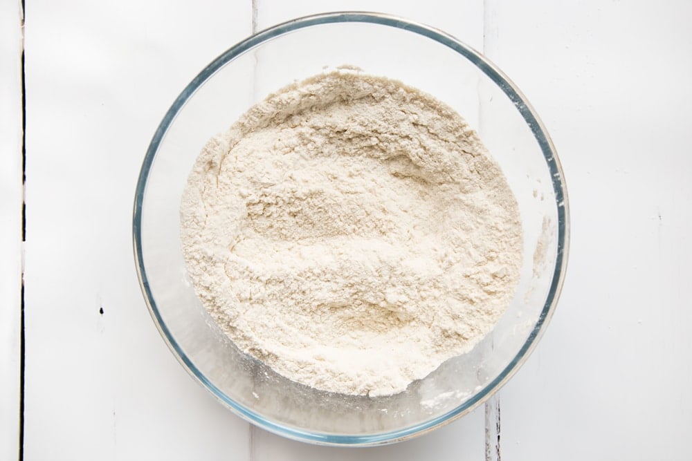 Mixing flour, arrowroot and baking powder in a bowl to make incredible Vegan american pancakes