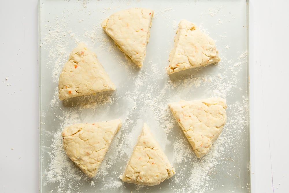 Chilli cheese savoury scone triangles on a floured baking tray