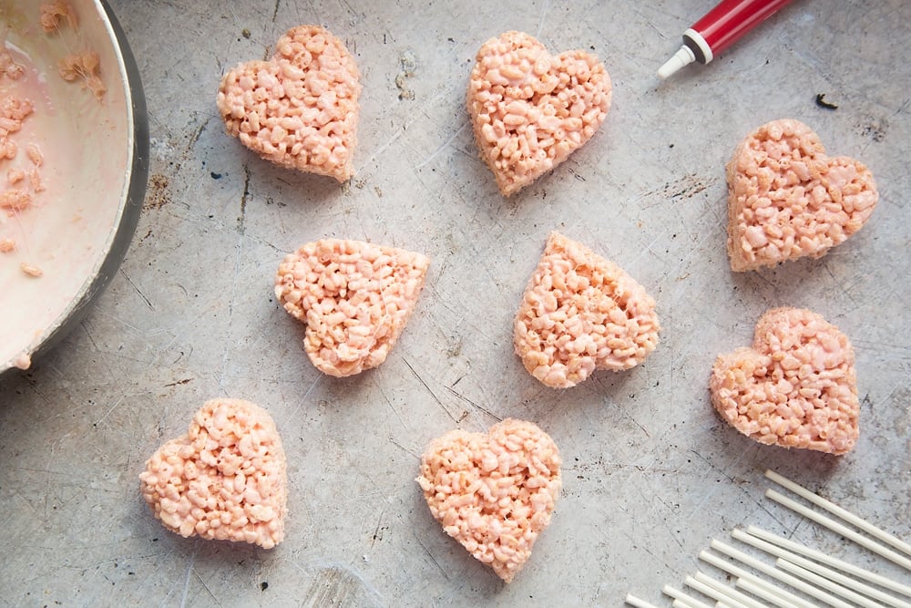 Heart shaped rice crispy treats ready to be put onto the stick to become cake pops. 