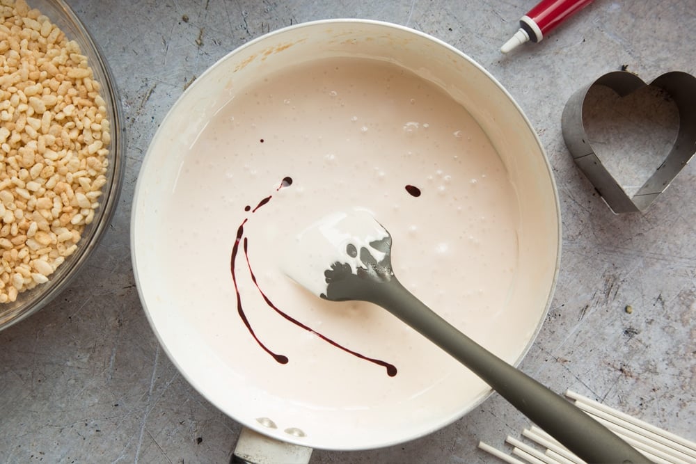 Adding food colouring to the heart crispy cake pops mix