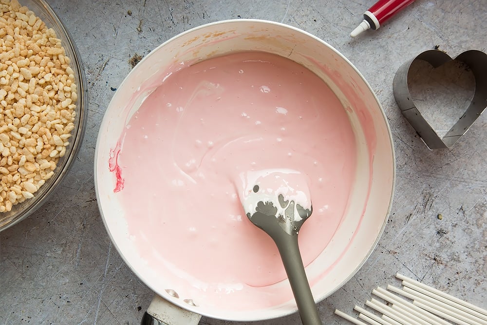 Pink melted marshmallow in pan ready to make the heart crispy cake pops mix