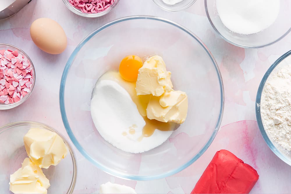 Overhead shot of margarine, sugar, eggs and vanilla in a large mixing bowl