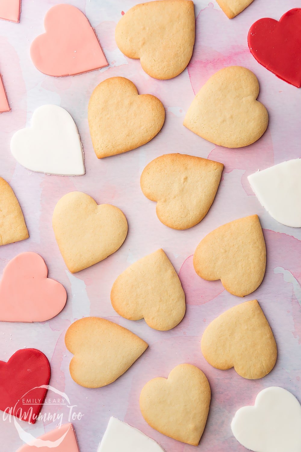 Overhead shot of heart shaped biscuits and fondant pieces with A Mummy Too logo in the bottom left hand corner