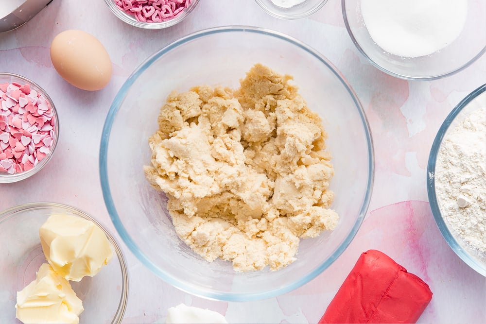 Overhead shot of valentines day cookie dough in a large clear bowl