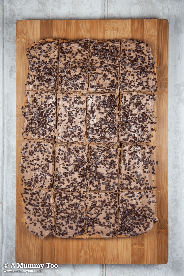 Chocolate Chip Cake Bars with Chocolate Cream Cheese Frosting cut into rectangles on a wooden chopping board