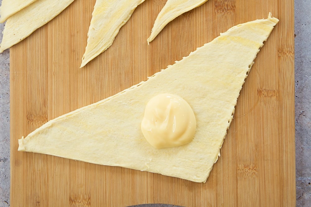 Add a spoonful of custard to the croissant dough triangle