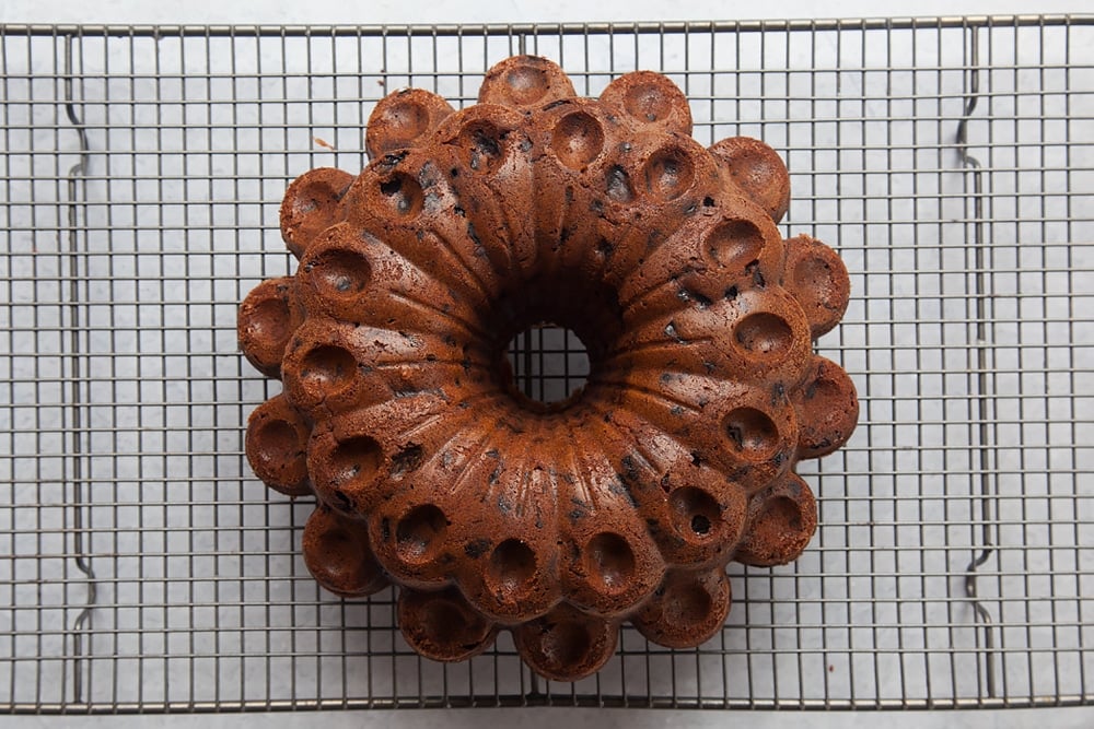 A baked tropical fruit cake on a wire cooling rack
