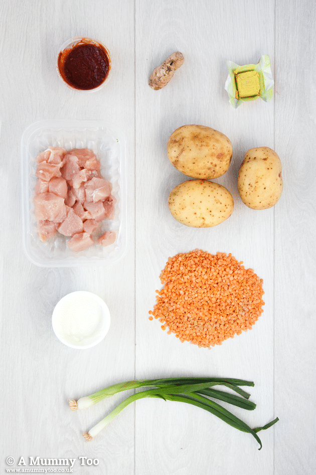 ingredidents for One pot harissa chicken curry including chicken, potatoes and spices laid out on a white background.