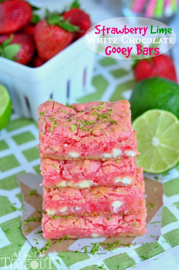 a stack of Strawberry Lime White Chocolate Gooey Bars with citrus fruits in the background.