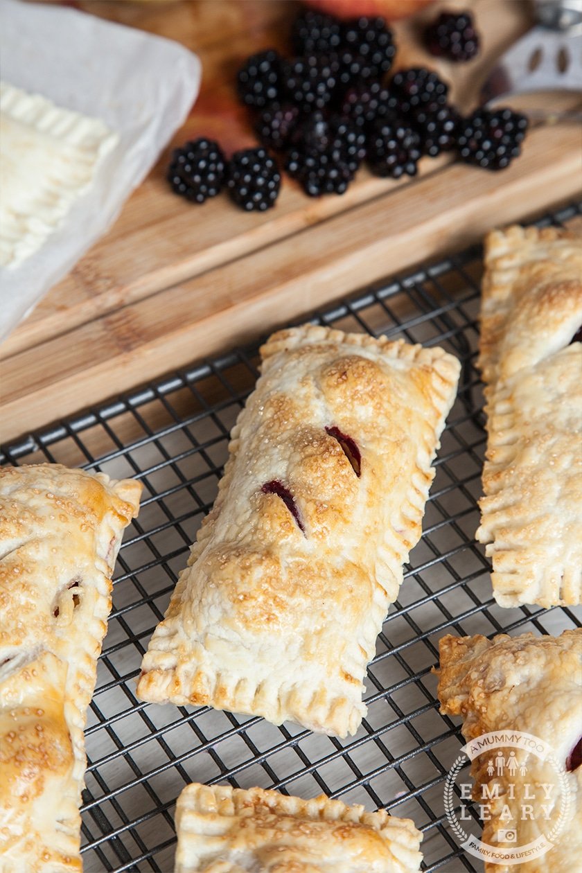 Apple and blackberry puff pastry parcels cooked on wire rack.