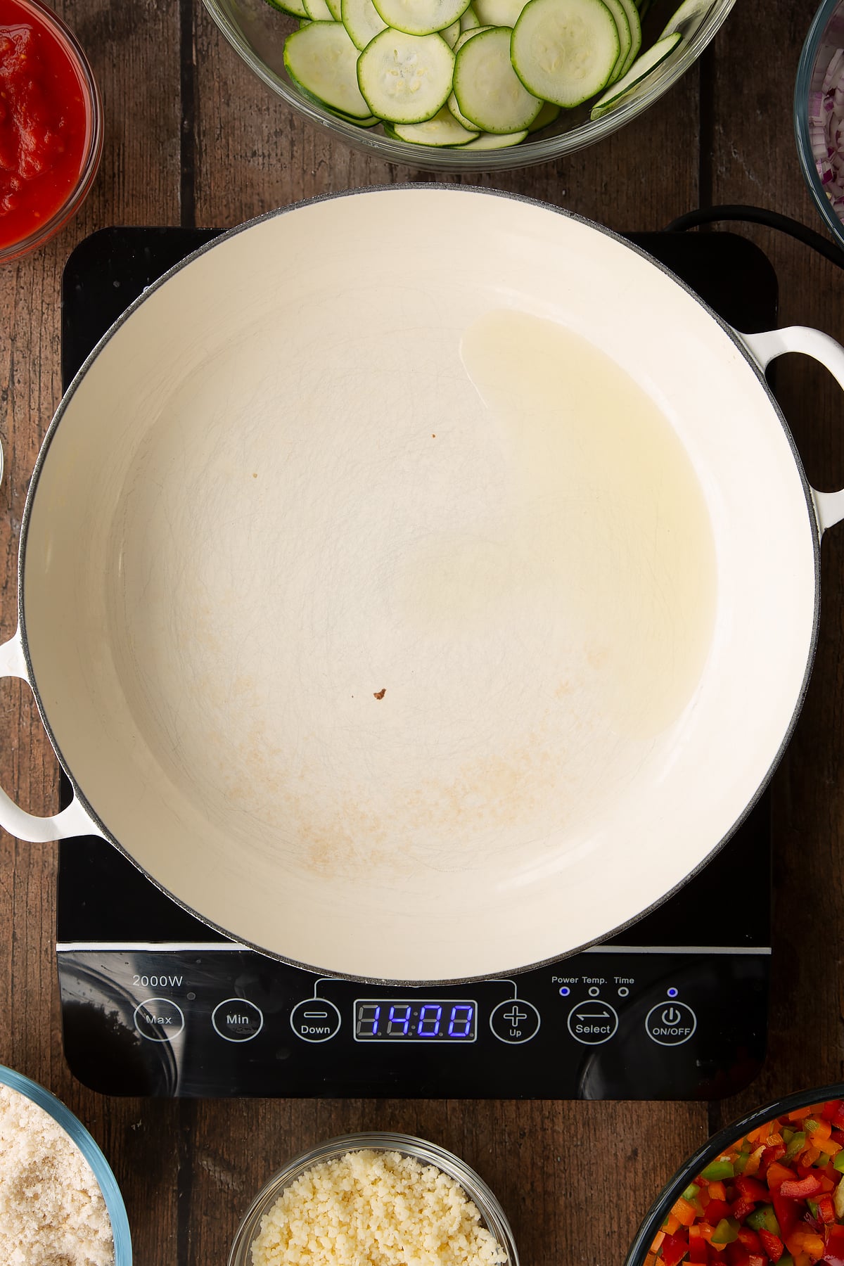 a large frying pan with a dash of oil on an induction hob.