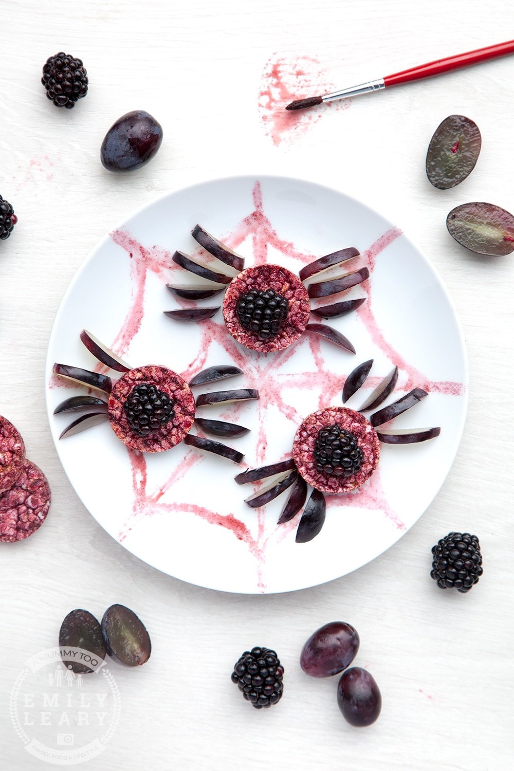 Halloween rice cakes, decorated with blackberries & grapes to look like spiders on a spider's web.
