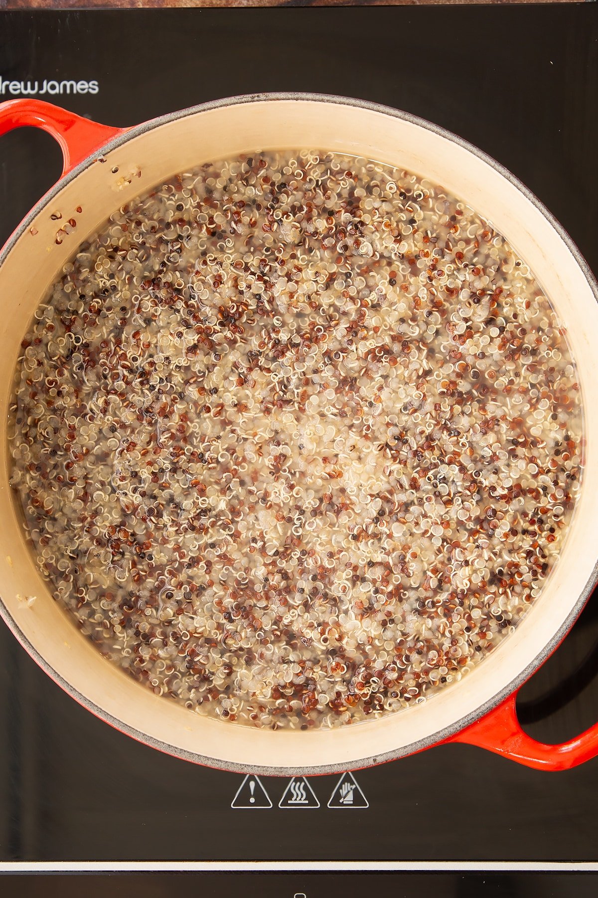Overhead shot of the cooked quinoa in a pan on the hob.