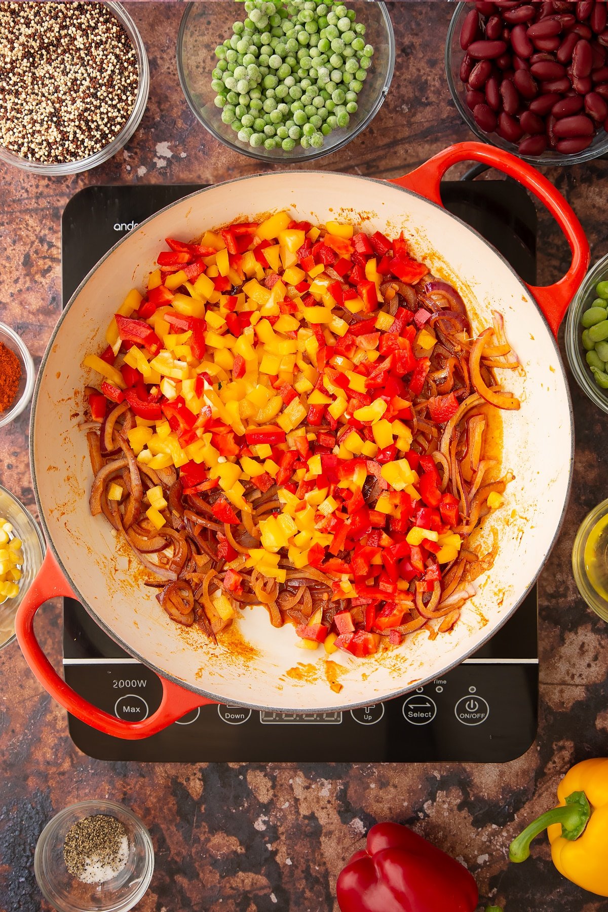 Overhead shot of some of the ingredients required to make the Zesty bean quinoa in a pan on the hob.