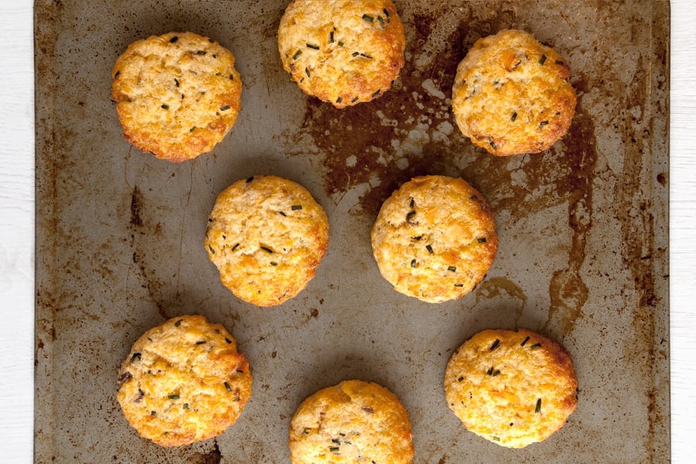 The baked fish cakes without breadcrumbs mixture having been baked in the oven for 20 minutes. The patties sit on a baking sheet. 