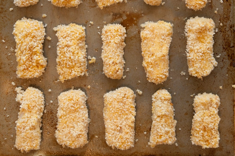 breaded fish goujons on a baking tray.