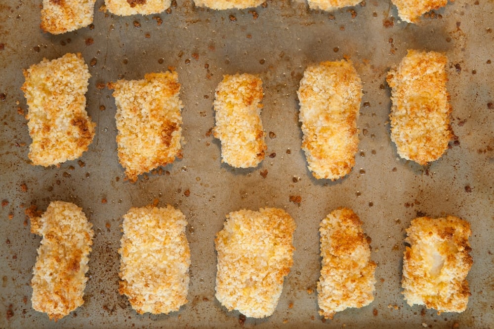 Freshly baked homemade fish goujons on a baking tray