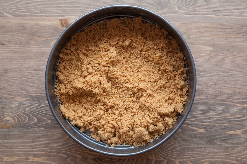 Digestive biscuit crumb mixed with melted butter and tipped into the base of a springform tin