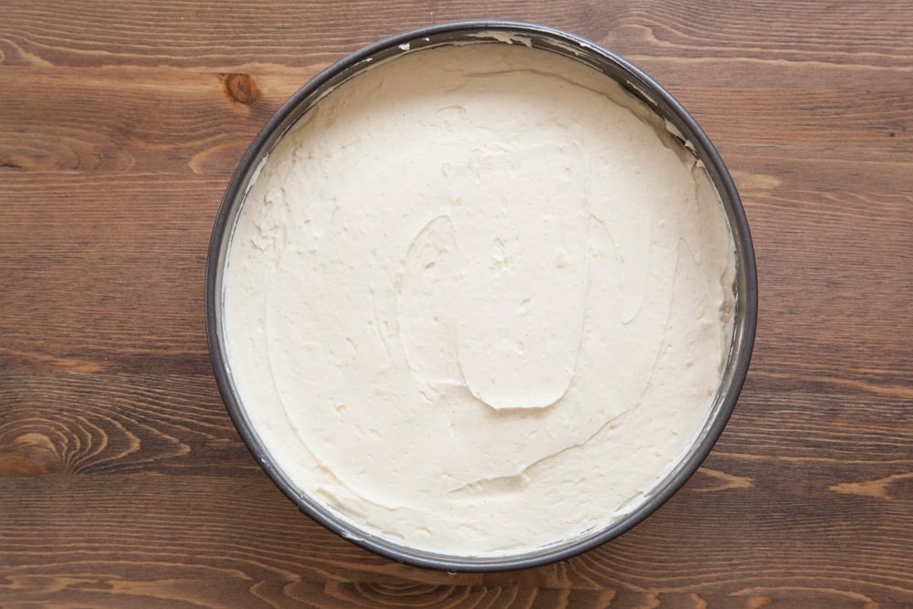 Digestive biscuit crumb mixed with melted butter and tipped into the base of a springform tin. Spread on top is the white chocolate cheesecake filling.