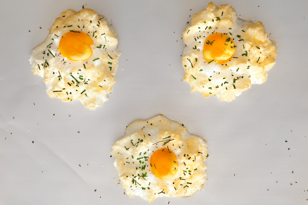 Freshly baked eggs in clouds with chives