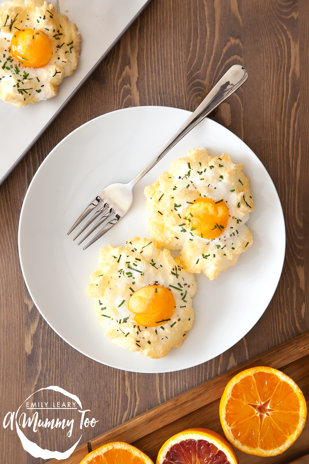 Eggs in clouds with chives. Two served on a plate with a fork.