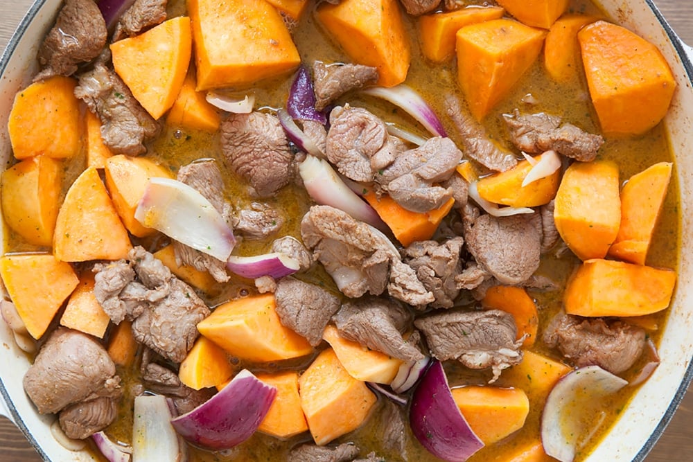 Slow cooked lamb and sweet potato casserole simmering in a pan