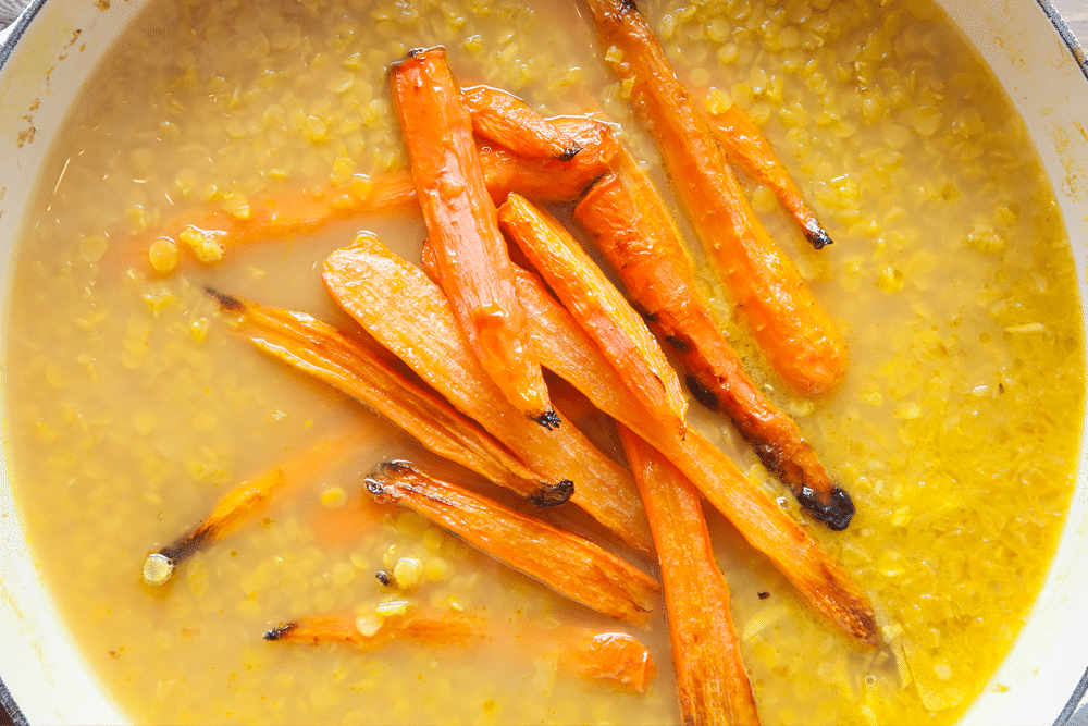 Roasted carrots are added to the pot