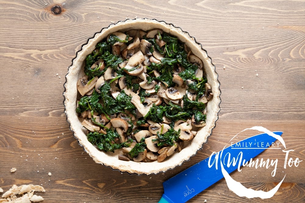 The spinach and mushroom mix is added to the quiche