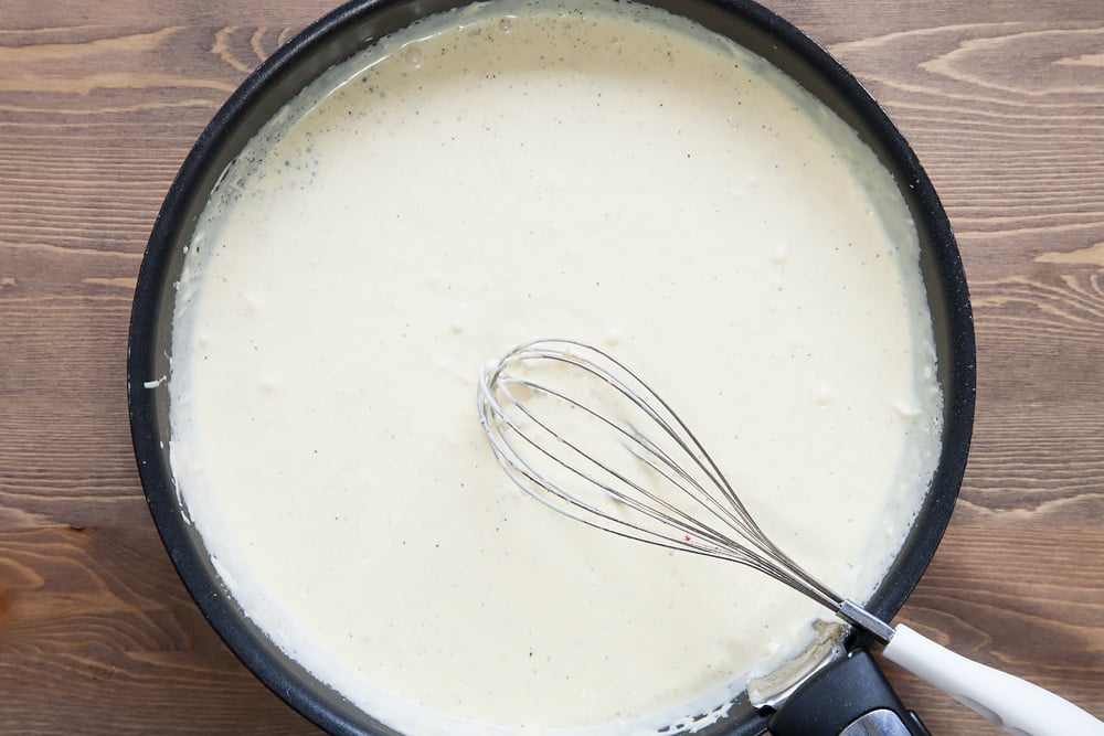 white creamy sauce mixed together and bubbling in a large frying pan