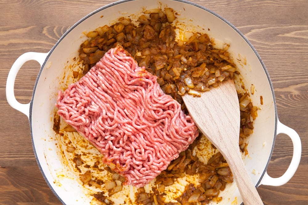 Adding lamb mince to the frying pan