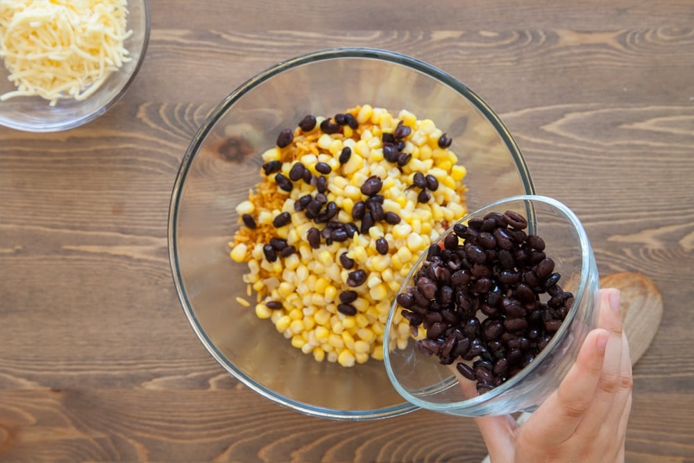 Mixing in the taco ingredients, adding black beans
