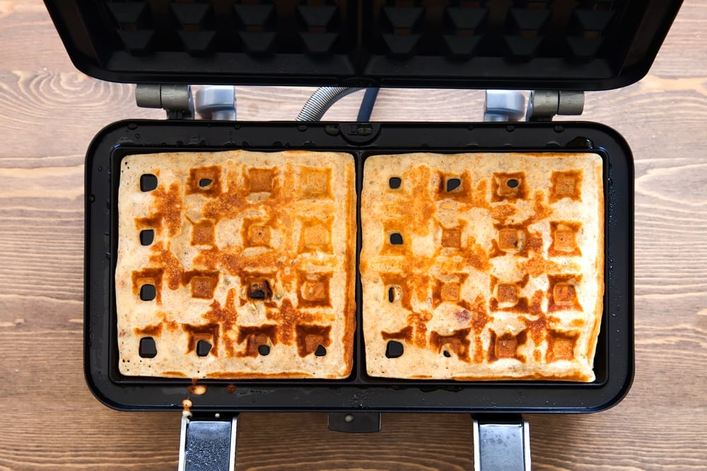 Cooking the granola waffles in a waffle maker until golden