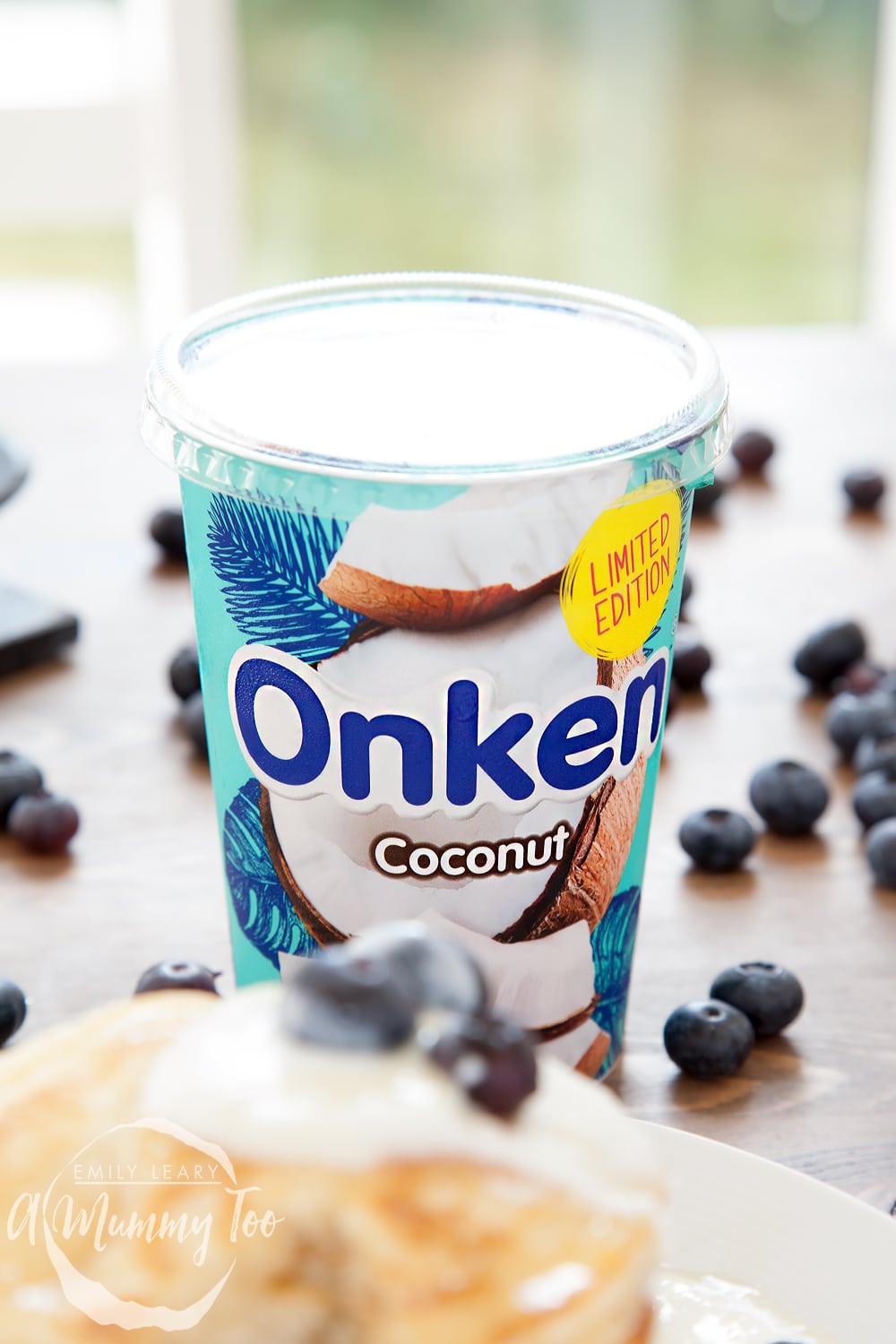 Onken coconut biopot yogurt surrounded by blueberries and fluffy panckes.